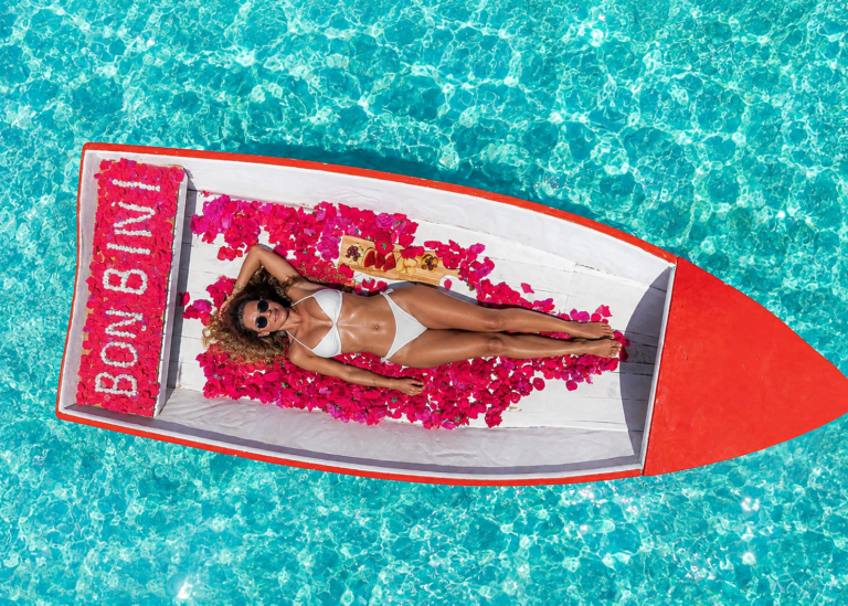 Woman relaxing on a Bon Bini branded boat float decorated with flower petals