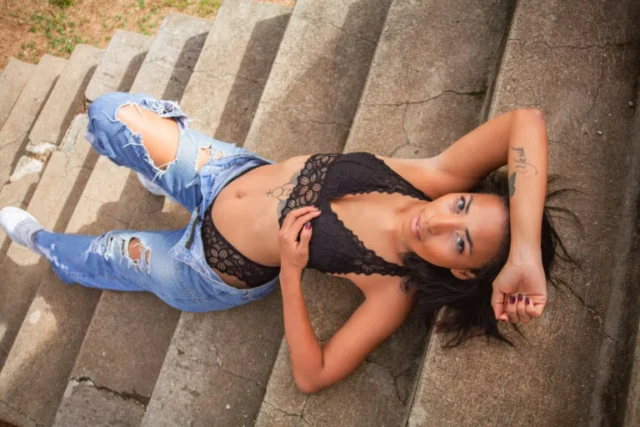 Woman in a glamour photoshoot pose on stone steps in Curacao