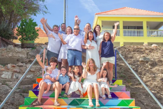Family group posing on a colorful painted staircase in Curacao