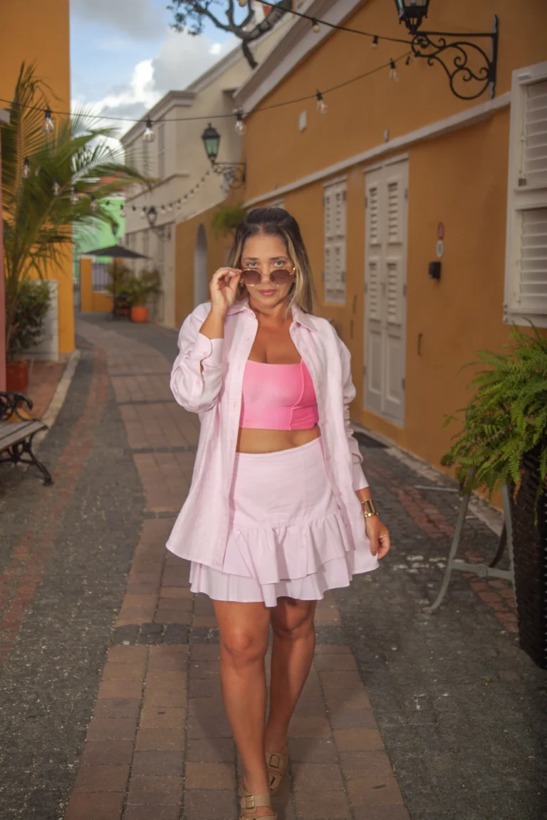 Woman in a pink outfit walking down a colorful street in Curacao